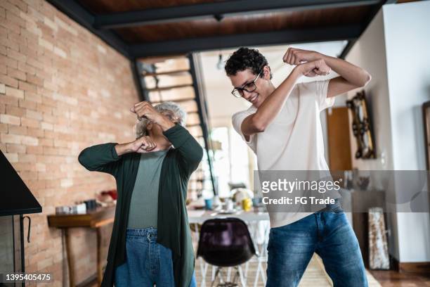 grandmother and grandson dancing at home - boy at television stockfoto's en -beelden