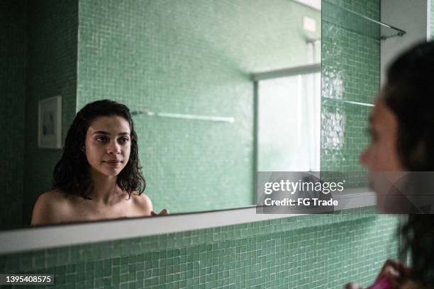 teenage girl looking in the mirror at home - girl in mirror stockfoto's en -beelden