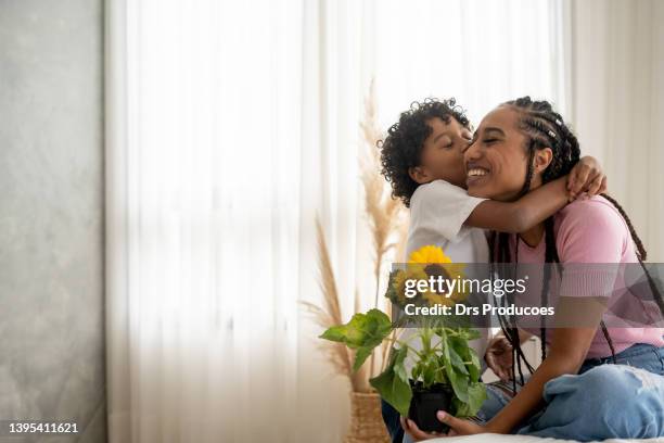 hijo entregando flor a su madre el día de la madre - dia de la madre fotografías e imágenes de stock