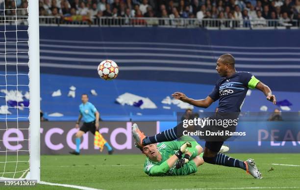 Fernandinho of Manchester City misses a shot whilst under pressure from Thibaut Courtois of Real Madrid during the UEFA Champions League Semi Final...