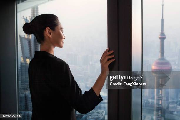 chinese woman proudly looking at real estate industry progress in downtown city, shanghai, china - travel real people stockfoto's en -beelden