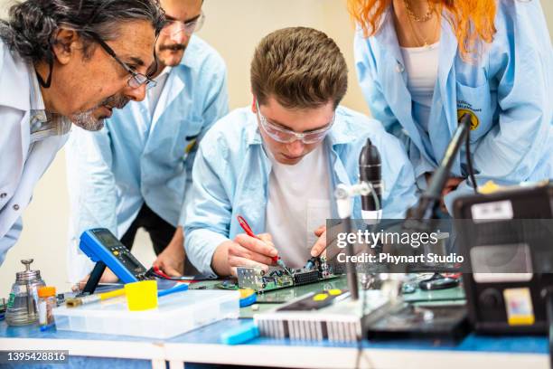 group of young people in technical vocational training with teacher - huishoudelijke apparatuur stockfoto's en -beelden