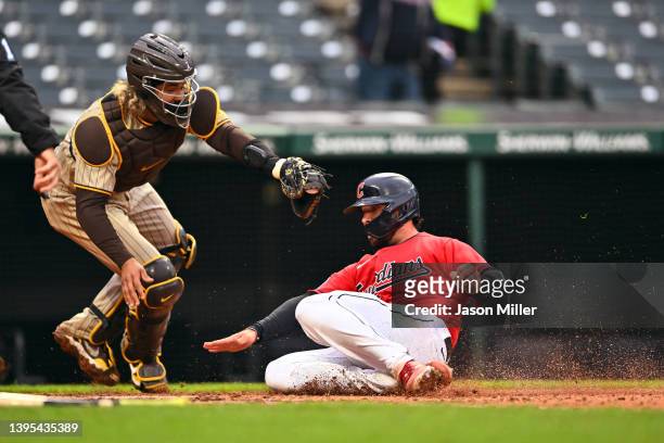 Catcher Jorge Alfaro of the San Diego Padres misses the tag as Austin Hedges of the Cleveland Guardians scores during the seventh inning of game two...