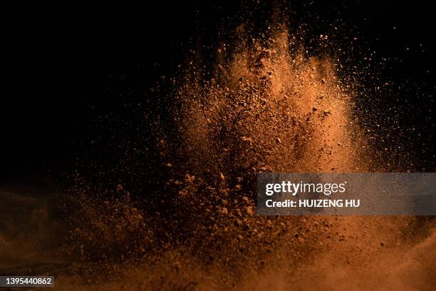 cocoa powder explosion in motion - kakaopulver stock-fotos und bilder