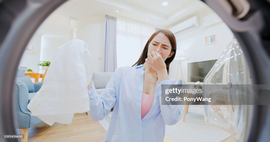 Woman take clothes from washer