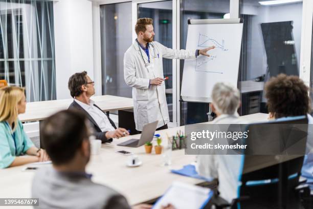 male doctor giving a business presentation in the office. - doctor and engineer stock pictures, royalty-free photos & images