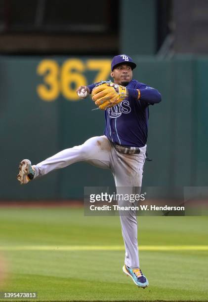 Wander Franco of the Tampa Bay Rays throws to first base off balance but not in time to get Chad Pinder of the Oakland Athletics in the top of the...