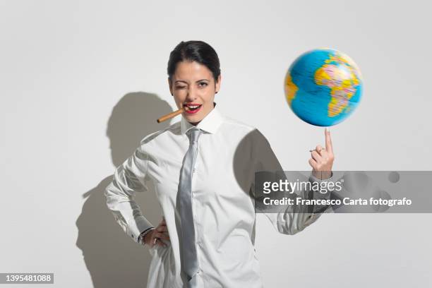 businesswoman with cigar balancing a globe with a finger - tobacco workers stockfoto's en -beelden