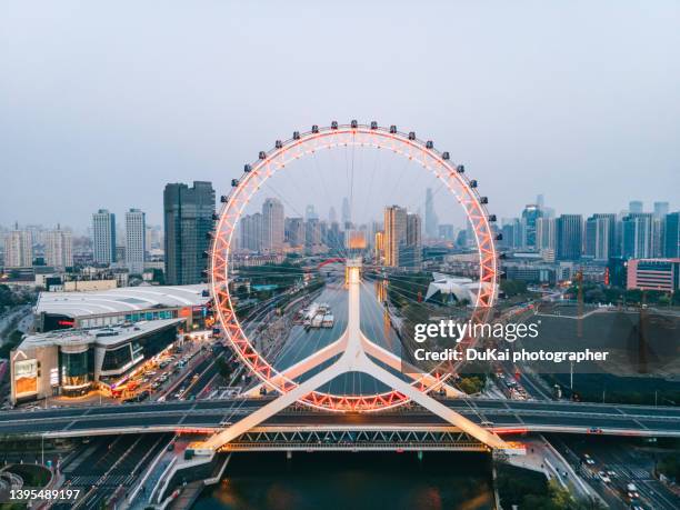 tianjin eye and tianjin urban skyline at night - grande roue photos et images de collection
