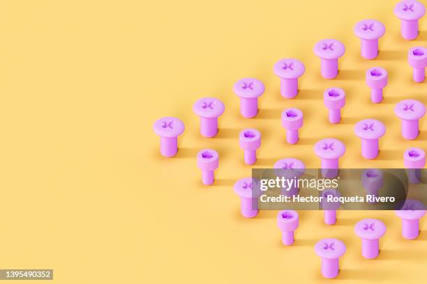 computer graphic of pink pile of screws on yeloow background, 3d render - nut fastener stock-fotos und bilder