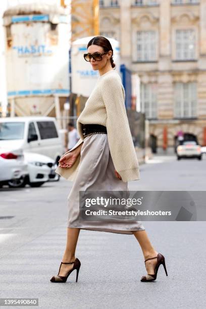 Federrock founder Anna von Schilcher wearing a beige colored cashmere pullover by Max Mara, a light silver satin dress by Max mara, a dark brown wide...