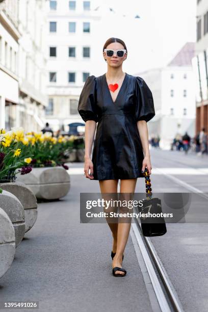 Federrock founder Anna von Schilcher wearing a dark brown leather dress by Ganni, dark brown sandals by Iris and Ink, sunglasses by Boss, a vintage...