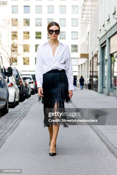 Federrock founder Anna von Schilcher wearing a white blouse by Seidensticker x Glamometer, a black fringe dress by The Outnet, black pumps by Manoli...