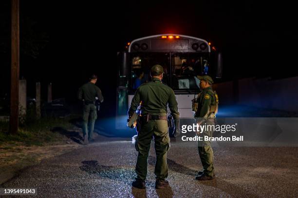 Border Patrol officers speak together after processing and loading migrants onto a bus on May 05, 2022 in Roma, Texas. Texas Gov. Greg Abbott's...