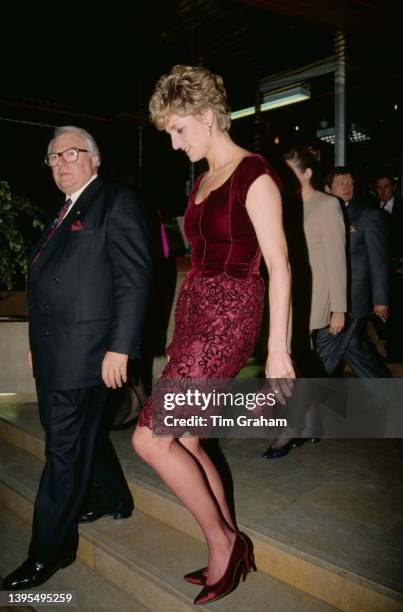 British Royal Diana, Princess of Wales , wearing a burgundy-coloured velvet and lace Valentino dress, attends a performance of Paul McCartney's...