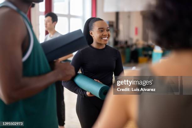 happy african woman talking with friends after workout session in yoga studio - yoga studio - fotografias e filmes do acervo