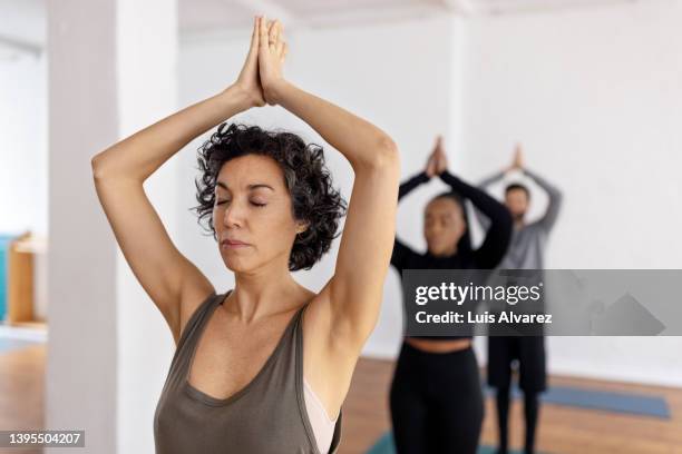 group of people practicing tree pose yoga in class - non moving activity stock pictures, royalty-free photos & images