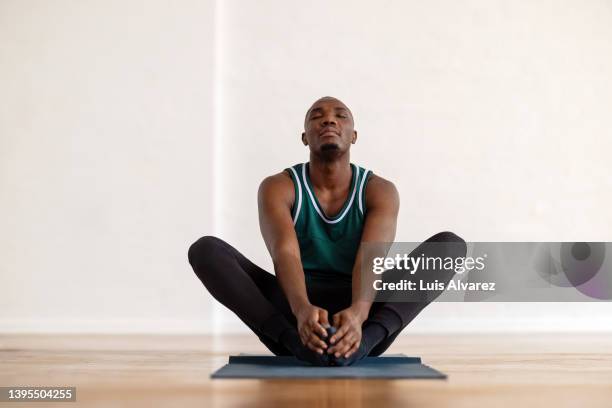 african man practice yoga in the butterfly position in yoga class - yoga 個照片及圖片檔