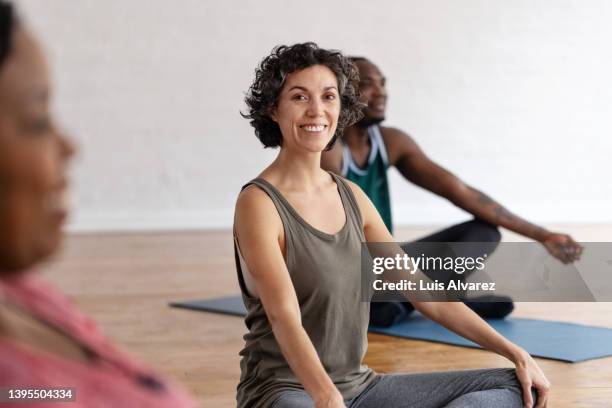 portrait of a happy mature woman sitting on yoga class - 45 49 jahre stock-fotos und bilder