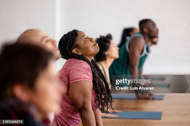 diverse group of people doing stretching yoga workout in gym - training class stockfoto's en -beelden