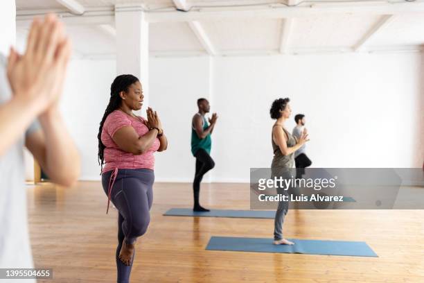 group of people doing yoga workout in gym class - human build imagens e fotografias de stock
