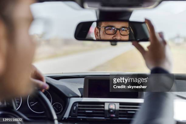 車のバックミラーを調整する男性の反射。 - 乗り物ミラー ストックフォトと画像