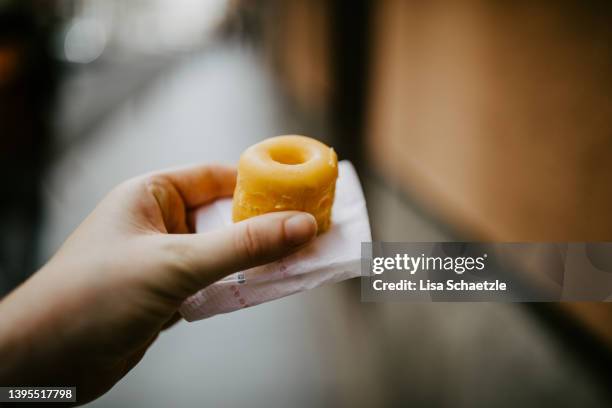 woman holding a small donut in her hand, yolk donuts (rosquillas de alcalá) - rosquillas photos et images de collection