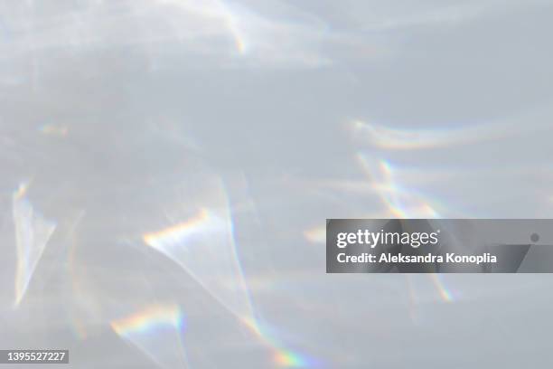 blurred dreamy surreal rainbow light refraction texture overlay effect on white wall - glow stock-fotos und bilder