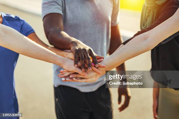 low angle view of sports men and women cheering themself for good teamwork after successful workout, - sports team high five stock pictures, royalty-free photos & images