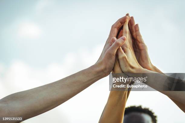 diverse team stacking their hands - sports team high five stock pictures, royalty-free photos & images