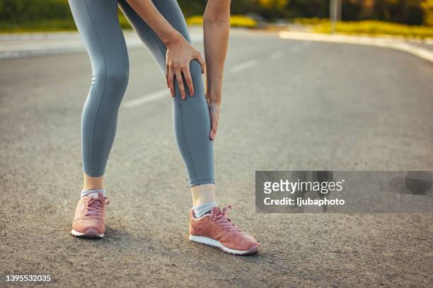 young sporty woman feeling pain - calf human leg stock pictures, royalty-free photos & images