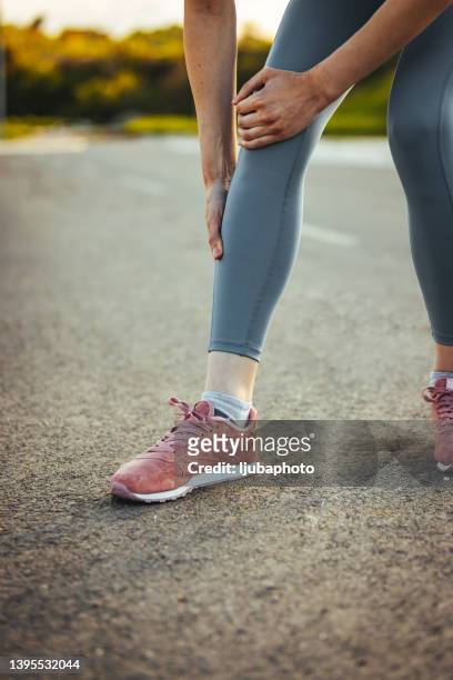 young sporty woman feeling pain in her knee. - swollen ankles stock pictures, royalty-free photos & images