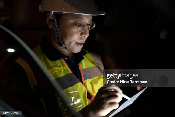 field service and support engineer solution. shot of a senior male japanese civil engineer or surveyor engineer doing daily report on a tablet inside car during onsite survey. - civil engineering fotografías e imágenes de stock