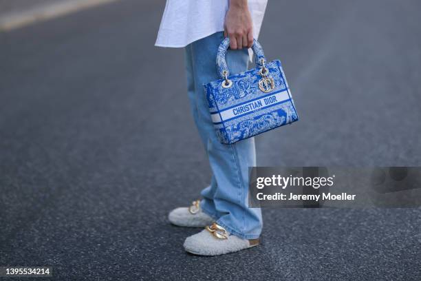 Sonia Lyson seen wearing a white shirt blouse from Miu Miu, a blue wide leg denim jeans from Weekday, a blue Lady Dior bag and white fluffy sandals...