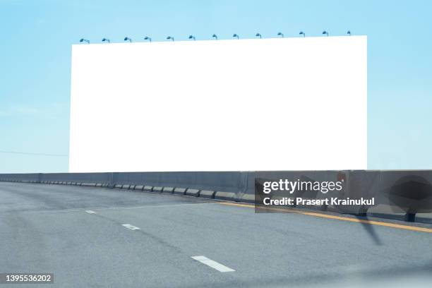 large billboard on empty road with blue sky.  mockup background - billboard highway stock-fotos und bilder