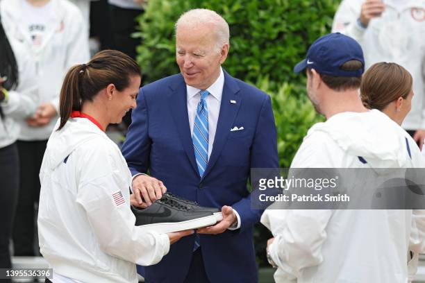 President Joe Biden is given a pair of Nike shoes and a Team USA shirt by Olympic Speedskater Brittany Bowe and Curler John Shuster on the South Lawn...