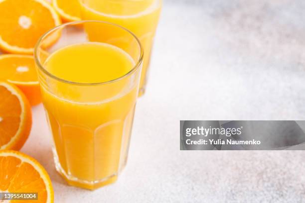 fresh orange juice and oranges on light background. - orange juice stock-fotos und bilder