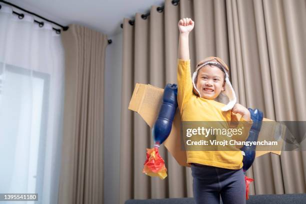 little girl playing astronaut with rocket wing at home - small smart girl stock pictures, royalty-free photos & images