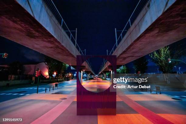 3d digital object with circle installed under stunning elevated train at night. - creative perspective stock pictures, royalty-free photos & images