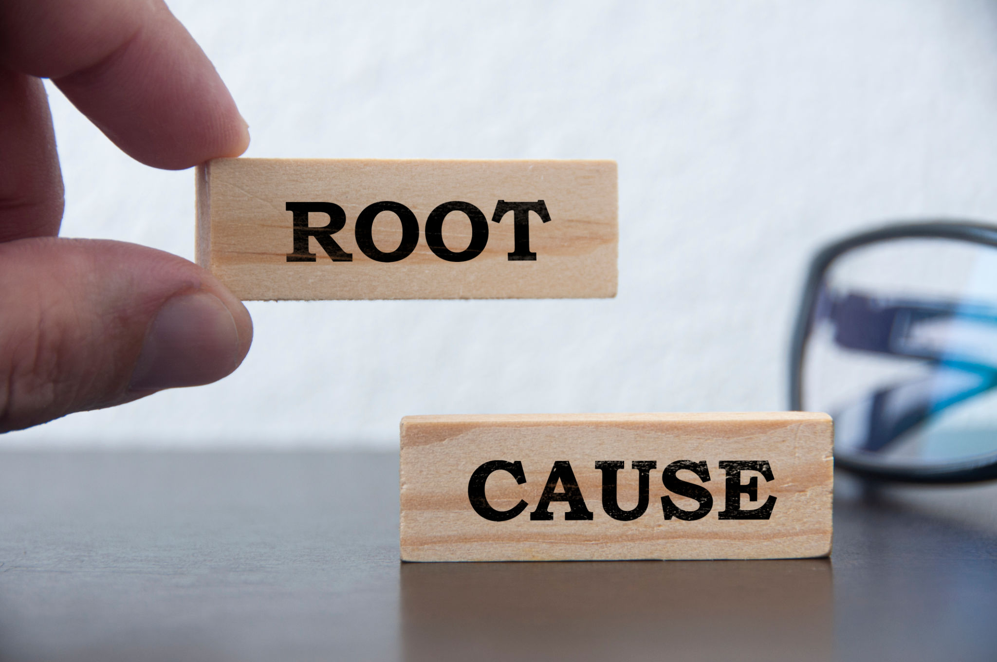 Hand holding wooden block with text - Root cause analysis. Problem solving and preventive concept Hand holding wooden block with text - Root cause analysis. Problem solving and preventive concept