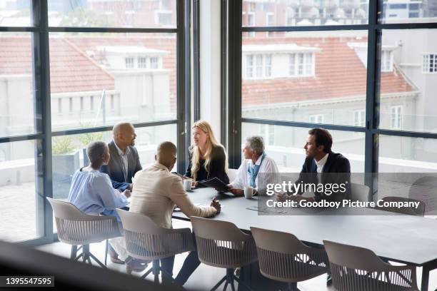 businesspeople talking together during a meeting in an office boardroom - boardroom stock pictures, royalty-free photos & images