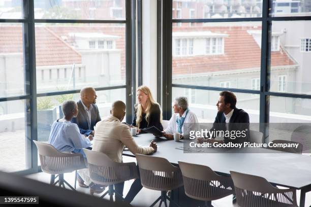 businesspeople talking together during a meeting in an office boardroom - board meeting imagens e fotografias de stock