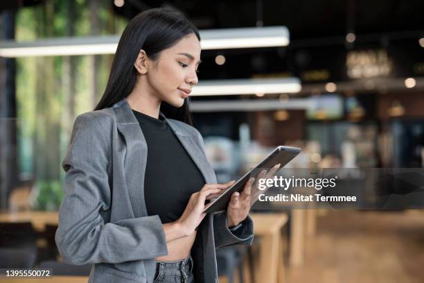 anywhere virtual remote working by using cloud based solution. portrait of a young businesswoman using a tablet to connect the system to use office data report in a lobby hotel during business trip. - financial advisor virtual stock pictures, royalty-free photos & images