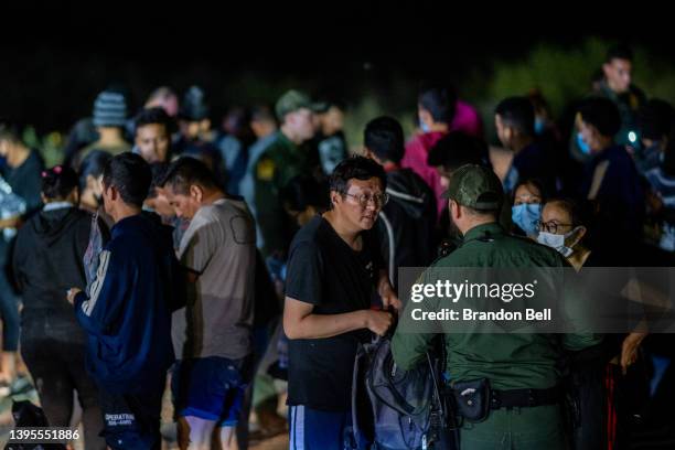 Chinese migrants speak to a border patrol officer before being processed after they crossed the Rio Grande into the U.S. On May 05, 2022 in Roma,...
