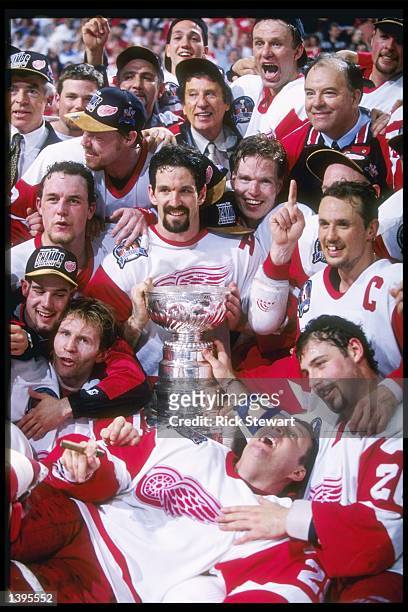 The Detroit Red Wings team gathers for a team picture with the Stanley Cup on the ice at Joe Louis Arena in Detroit, Michigan. The Red Wings won the...