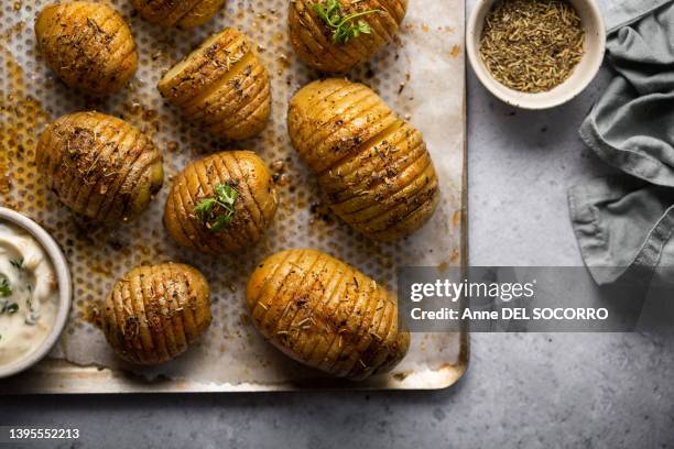 hasselback roasted potatoes with yogurt sauce salad and parsley - mode de cuisson des aliments photos et images de collection