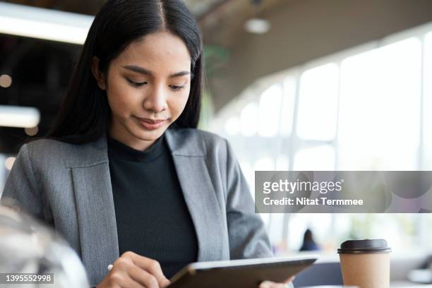 finding a financial advisor or financial planner if you want to need we can provide and support. confident of female financial advisor using a tablet in a financial business office. - software as a service stock pictures, royalty-free photos & images