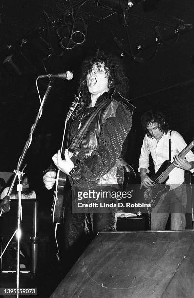 Wearing bat wings, singer-guitarist Marc Bolan performs with T Rex at the Joint in the Woods, October 2, 1974. Bassist Steve Currie at right.
