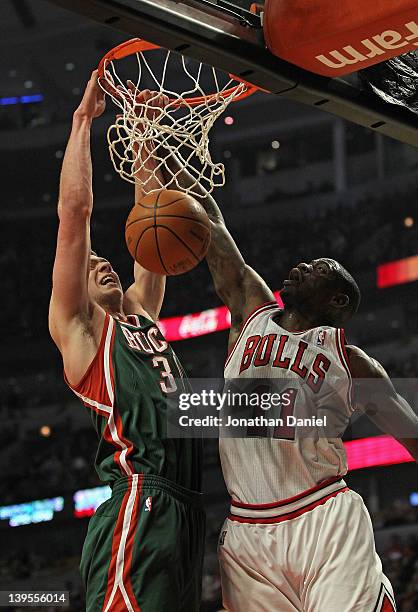 Jon Leuer of the Milwaukee Bucks dunks the ball over Ronnie Brewer of the Chicago Bulls at the United Center on February 22, 2012 in Chicago,...
