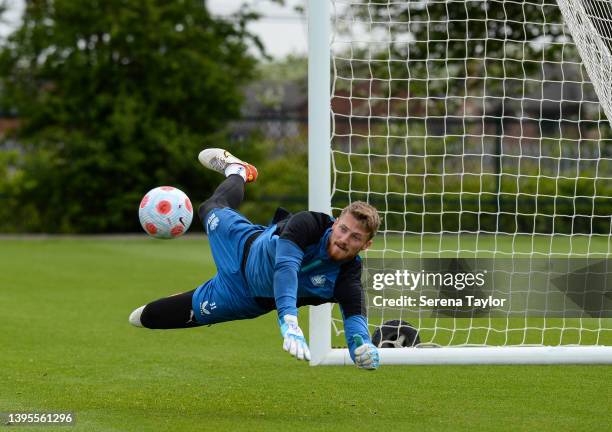 Goalkeeper Jake Turner dives to save the ball during the Newcastle United Training Session at the Newcastle United Training Centre on May 05, 2022 in...